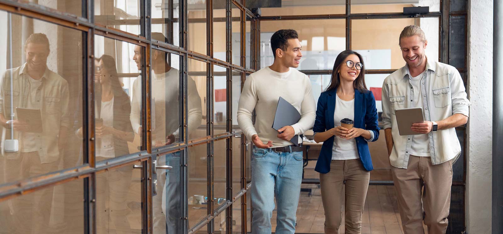 Three coworkers walking in office.