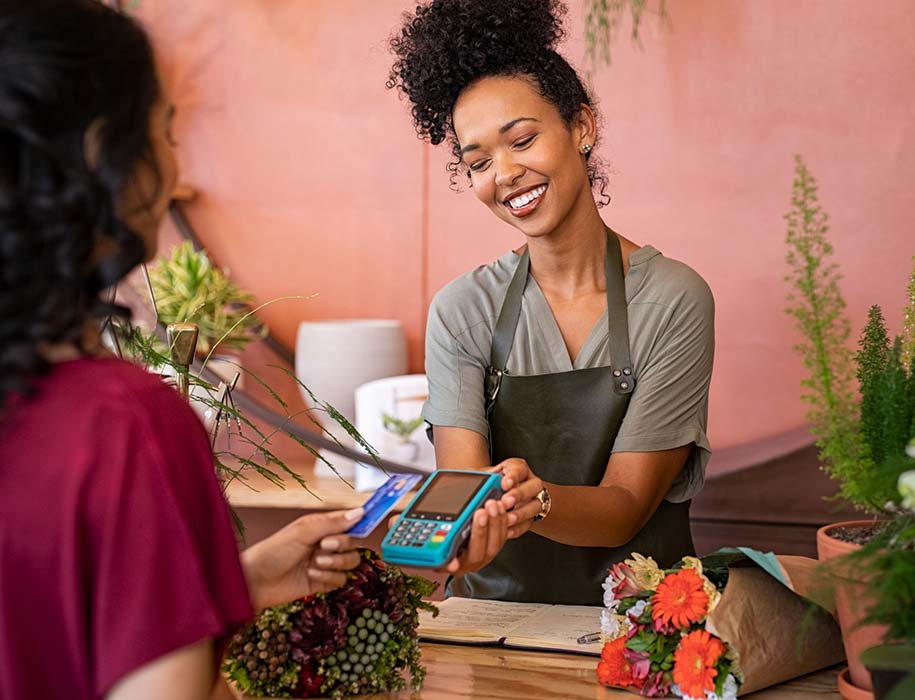 Woman using card to make payment at flower shop.