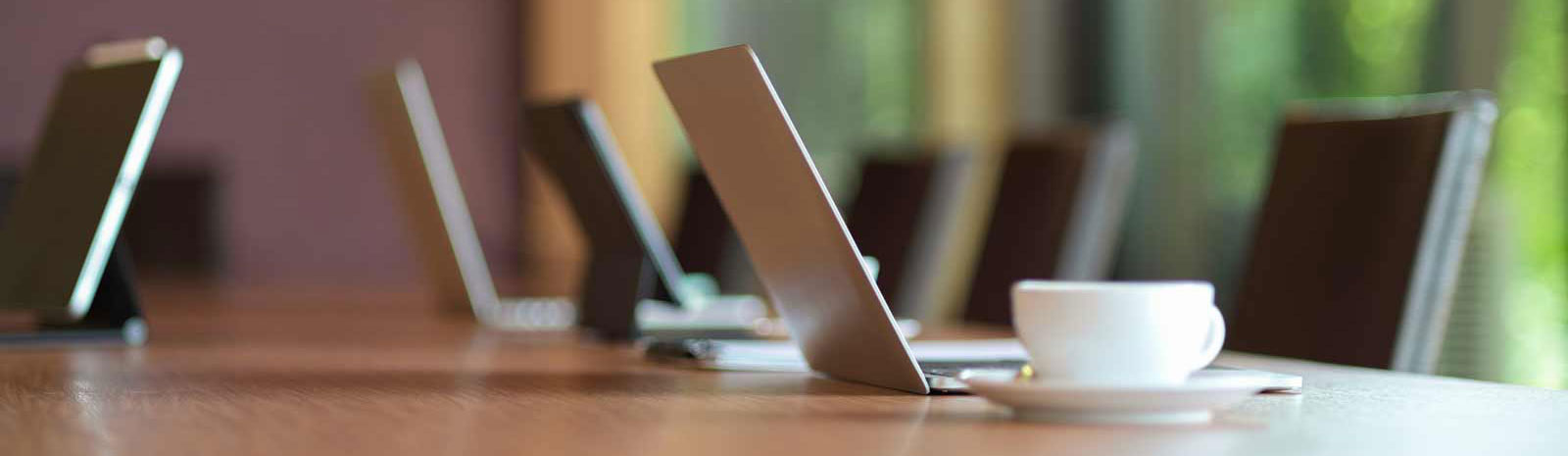 Board room with laptops and chairs.