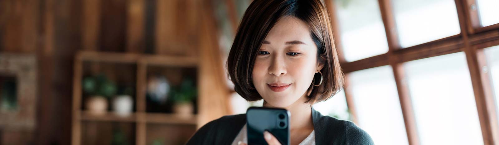 Woman in shop looking at phone.